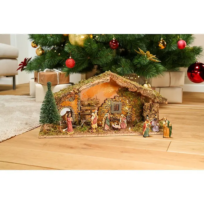 LED-Krippe Natur - 25 x 58 x 23 cm - Detaillierte Krippenszene mit Figuren unter einem geschmückten Weihnachtsbaum und Geschenken.