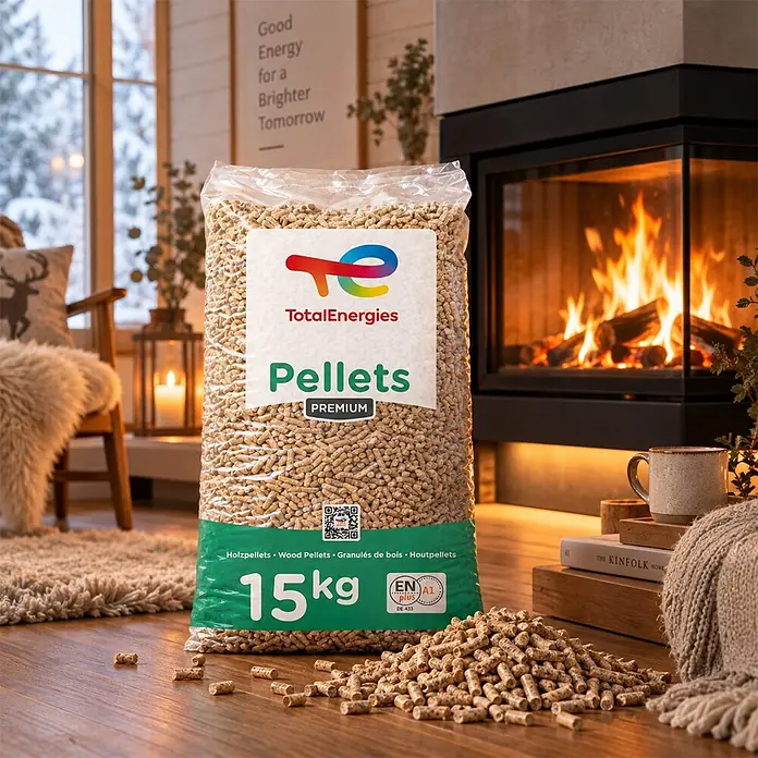 Total Energies Holzpellets Premium ENplus A1 Weichholz 15kg x 2 Sack 30kg -  - TotalEnergies Premium 15kg Holzpelletsack in gemütlichem Raum mit Kaminfeuer, einige Pellets auf dem Boden verstreut.