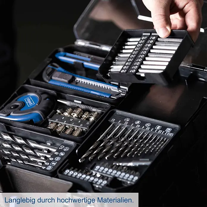 Scheppach IXES 20V Akku-Bohrschrauber-Set C-DTB74/1-X - 20 V, 1 Akku, 2 Ah, 50 Nm, 74-tlg. Zubehör-Set - Eine Hand entnimmt ein Schrauberbit-Set aus einem umfassenden schwarzen Werkzeugkoffer, der auch Cuttermesser, Maßband, Stecknüsse und Bohrer enthält.