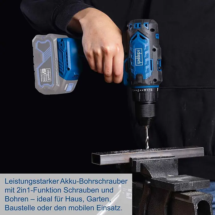 Scheppach IXES 20V Akku-Bohrschrauber C-DD45-X - 20 V, Ohne Akku, 45 Nm - Eine blau-schwarze Scheppach Akku-Bohrmaschine mit grauem Akku bohrt in einen Metallträger im Schraubstock.