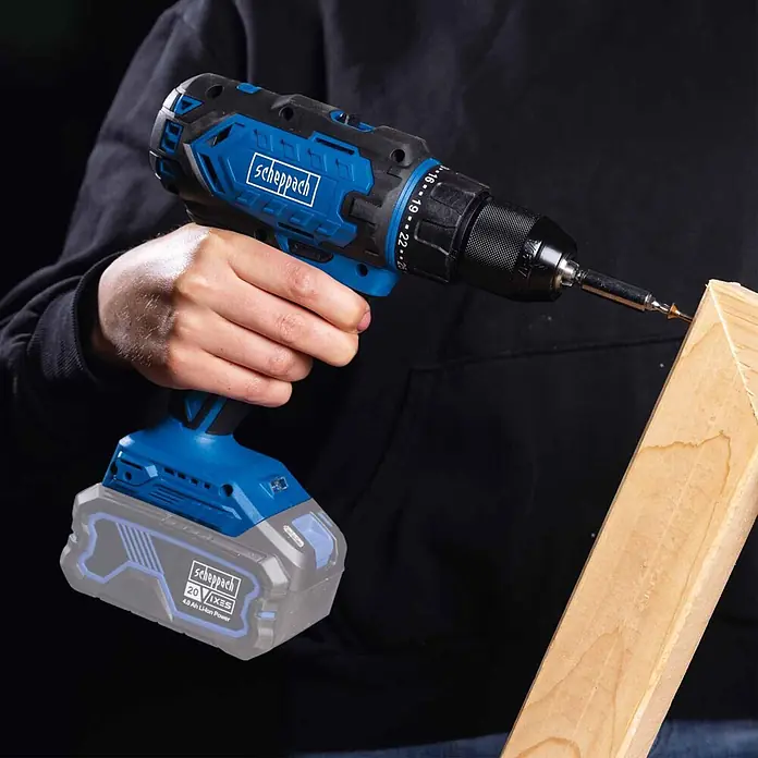 Scheppach IXES 20V Akku-Bohrschrauber C-DD45-X - 20 V, Ohne Akku, 45 Nm - Blau-schwarzer Scheppach Akku-Bohrschrauber treibt eine Schraube in Holz.