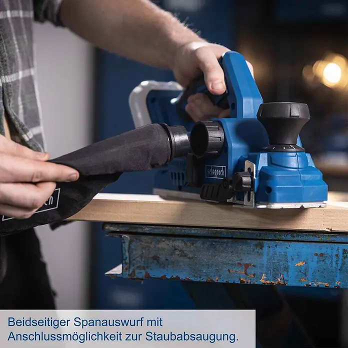 Scheppach IXES 20V Akku-Hobel BC-PLM82-X - 20 V, Ohne Akku, Hobeltiefe: 0 mm - 2 mm, Leerlaufdrehzahl: 15.000 U/min - Person hobelt Holz mit blauem Elektrohobel, der über einen Staubfangsack und Absauganschluss verfügt.