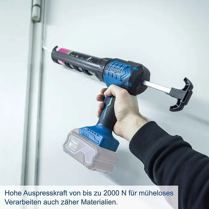 Scheppach IXES 20V Akku-Kartuschenpresse C-SEG310-X - 20 V, Ohne Akku - Eine Hand hält eine blau-schwarze Scheppach Akku-Kartuschenpistole und trägt weißen Dichtstoff auf eine vertikale Fuge auf.