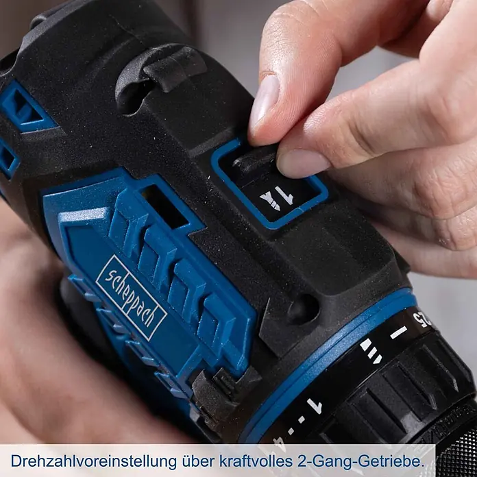 Scheppach IXES 20V Akku-Bohrschrauber BC-DD60-X - 20 V, Ohne Akku, 60 Nm - Eine Hand verstellt den 2-Gang-Wahlschalter eines schwarz-blauen Scheppach Akkuschraubers.