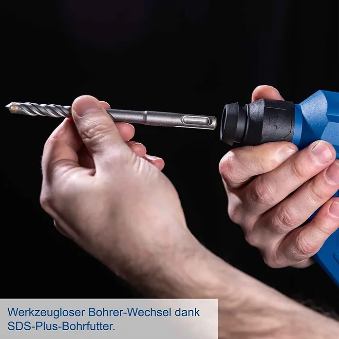 Scheppach IXES 20V Akku-Bohrhammer C-RHD130-X - 20 V, Ohne Akku, 1,3 J - Eine Person führt einen grauen SDS-Plus-Bohrer in das blaue Bohrhammerfutter ein. Werkzeugloser Bohrerwechsel.