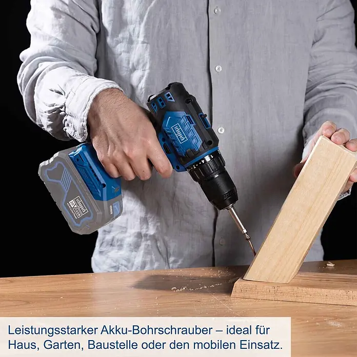 Scheppach IXES 20V Akku-Bohrschrauber BC-DD60-X - 20 V, Ohne Akku, 60 Nm - Eine Person benutzt einen blau-schwarzen Akku-Bohrschrauber, um eine Schraube in ein Holzstück zu treiben. Der Akku ist grau mit blauen Akzenten.