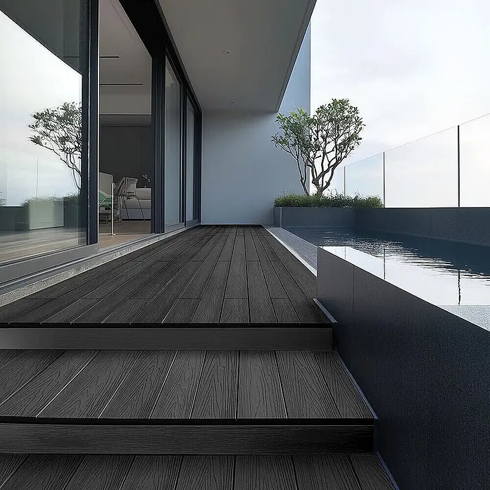 Home Deluxe WPC Terrassendielen SAMANA PREMIUM Anthrazit 2m² -  - Dunkelgraue WPC-Terrassendielen auf einer modernen Außenterrasse mit integrierten Stufen und Poolbereich.