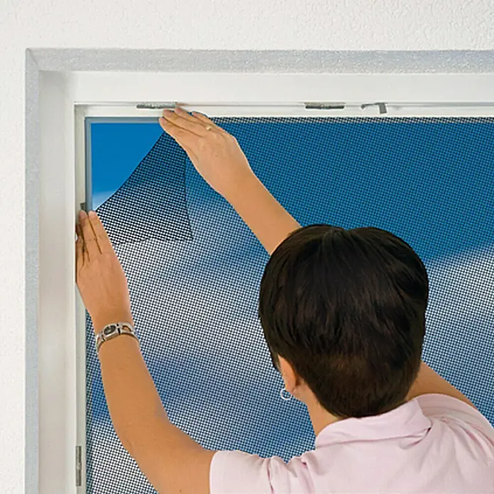 Easy Life Elastic Insektenschutzgitter - B x H: 130 x 150 cm, Weiß, Montage Insektengitter: Ankletten - Die Person bringt ein Insektenschutzgitter an einem Fenster an, um Insekten draußen zu halten.