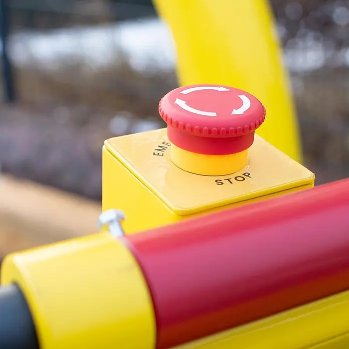 BAMATO Holzhäcksler HACK-150POWER 9kW bis 120mm mit E-Start -  - Roter Not-Aus-Knopf mit weißen Pfeilen auf gelbem Bedienfeld, an Industriemaschinen montiert.