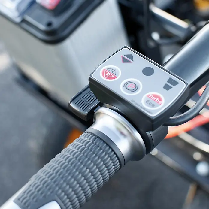 BAMATO Elektrische Schubkarre MTR-300W 300kg Traglast 400W -  - Graues Bedienfeld mit D/R, P und Turbo Eco Tasten auf einem schwarz-silbernen Lenkergriff.