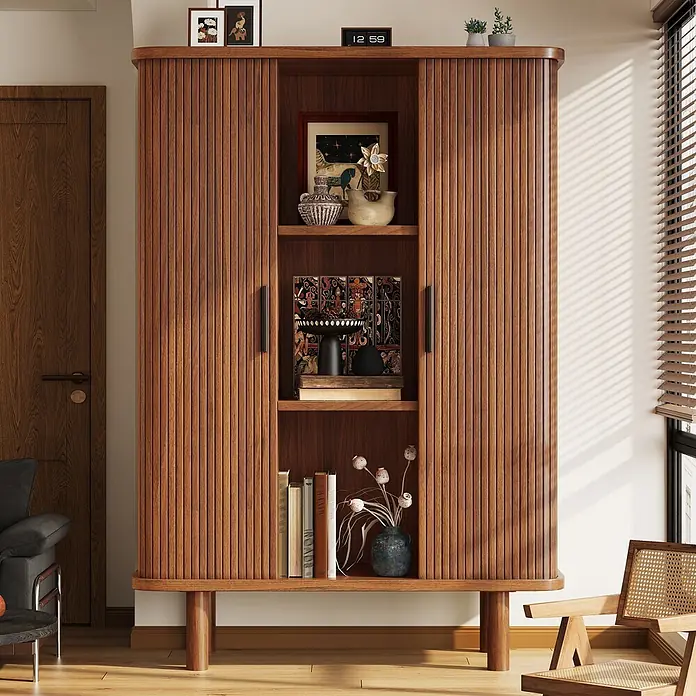 SONNENH Holz-Mehrzweckschrank mit Rollladentüren, Dunkelbraun -  - Ein hellbrauner Holzschrank mit Lamellentüren und offenen Regalen, gefüllt mit Deko und Büchern, in einem Wohnraum.