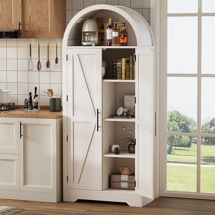 SONNENH Mehrzweckschrank mit Bogenabschluss und zwei Türen, Weiß -  - Ein hoher, weißer Küchenschrank mit gewölbter Oberseite, unteren Türen im Scheunentor-Stil und einem offenen Fach, gefüllt mit Küchenutensilien, neben einem Fenster.