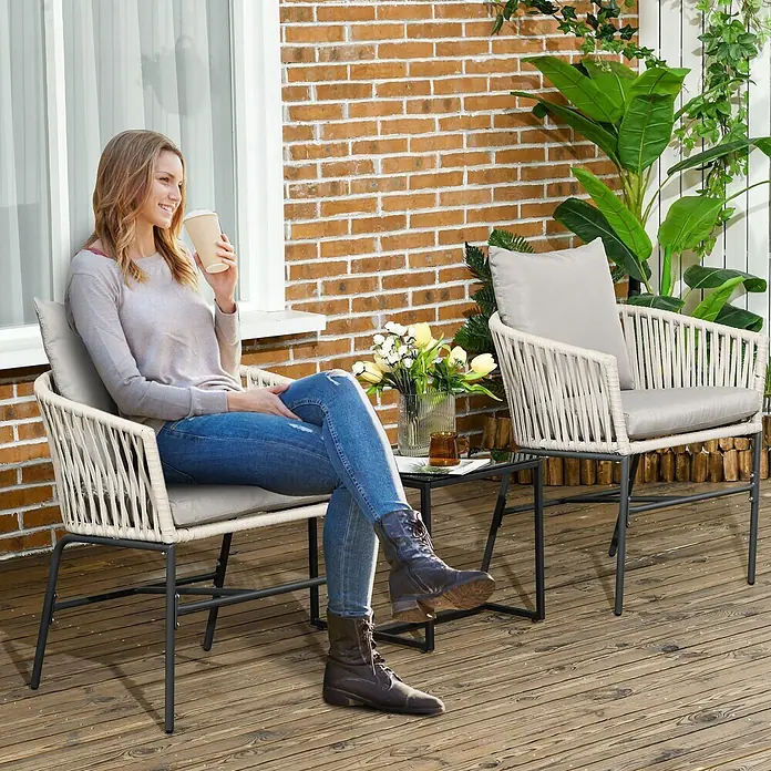 Outsunny Gartenstühle Beige 57L x 60B x 71H cm -  - Ein Outdoor-Terrassenset mit zwei hellbeigen Seilstühlen mit grauen Kissen und einem schwarzen Metall-Glas-Tisch auf einer Holzterrasse.