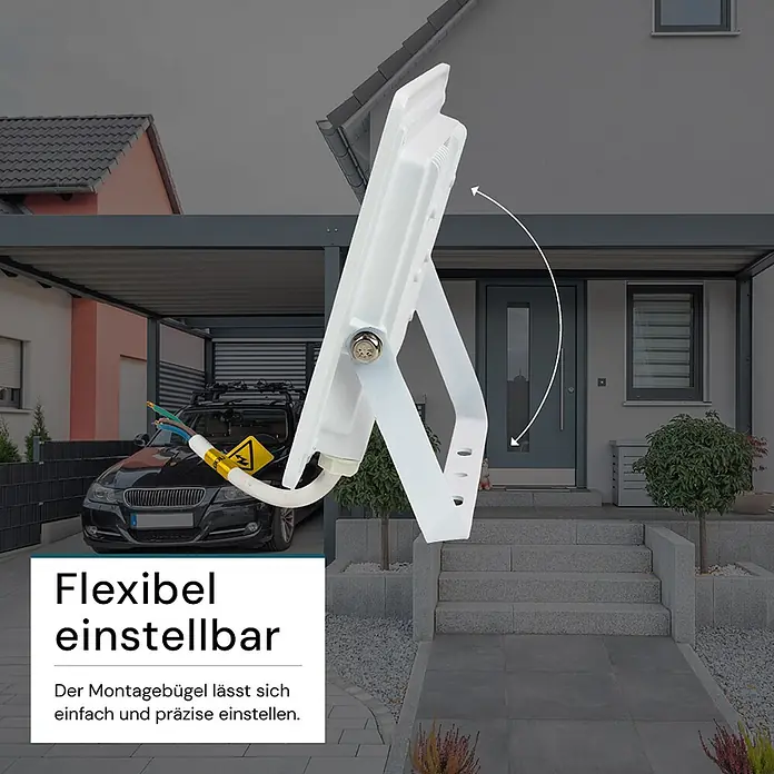 Luxula LED-Strahler - 50 W, 5.000 lm, IP65 - Weißer LED-Fluter mit verstellbarem Montagebügel, in einer Außenansicht eines Hauses. Ein Pfeil zeigt die Einstellbarkeit des Bügels.