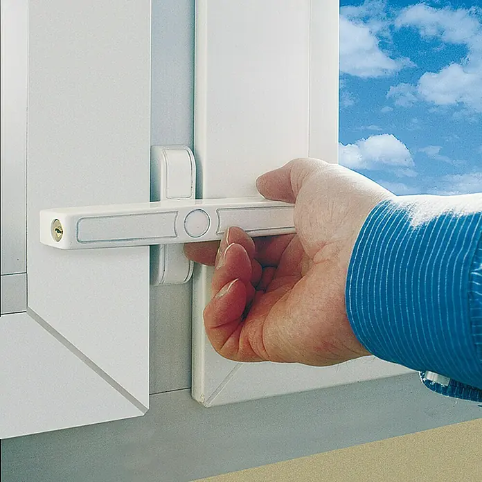 Abus Fenster-Zusatzschloss 2420 - Geeignet für: Nach innen öffnende, zweiflügelige Fenster - Eine Hand bedient ein weißes Fenster mit einem abschließbaren Fenstergriff. Der Griff bietet zusätzliche Sicherheit und Schutz vor Einbruch.