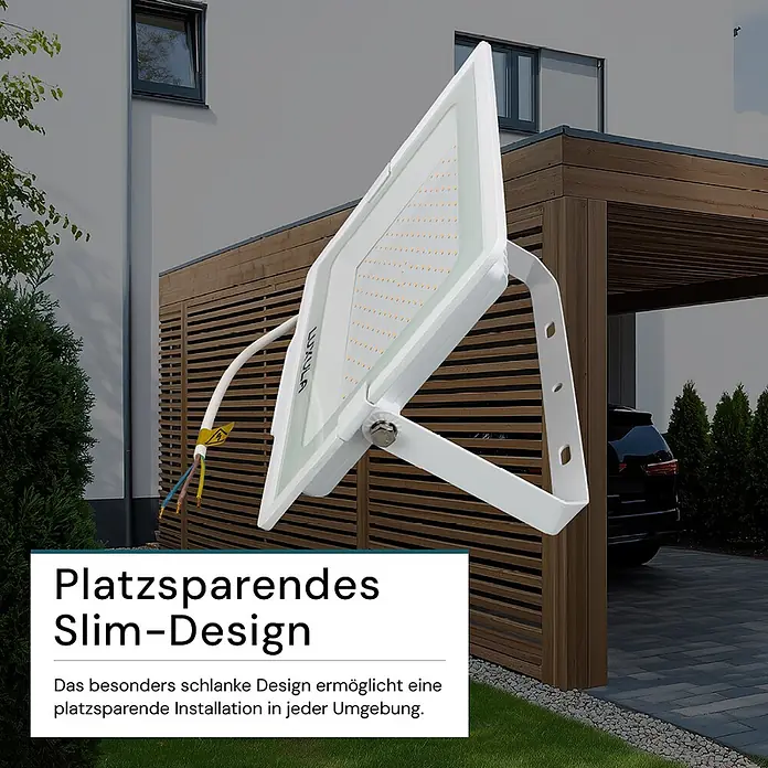 Luxula LED-Strahler - 150 W, 15.000 lm, IP65 - Weißer LUXULA LED-Fluter mit schlankem Design, in Außenumgebung nahe Haus und Carport, betont platzsparende Installation.