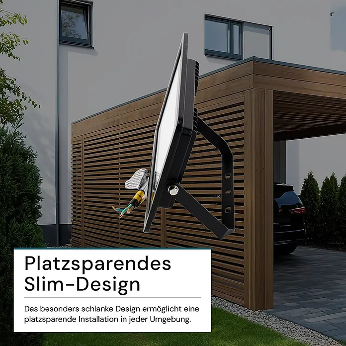 Luxula LED-Strahler - 30 W, 3.000 lm, 4.000 K, IP65 - Schlanker schwarzer LED-Flutlichtstrahler für den Außenbereich, der sein platzsparendes Design vor einem Haus mit Carport zeigt.