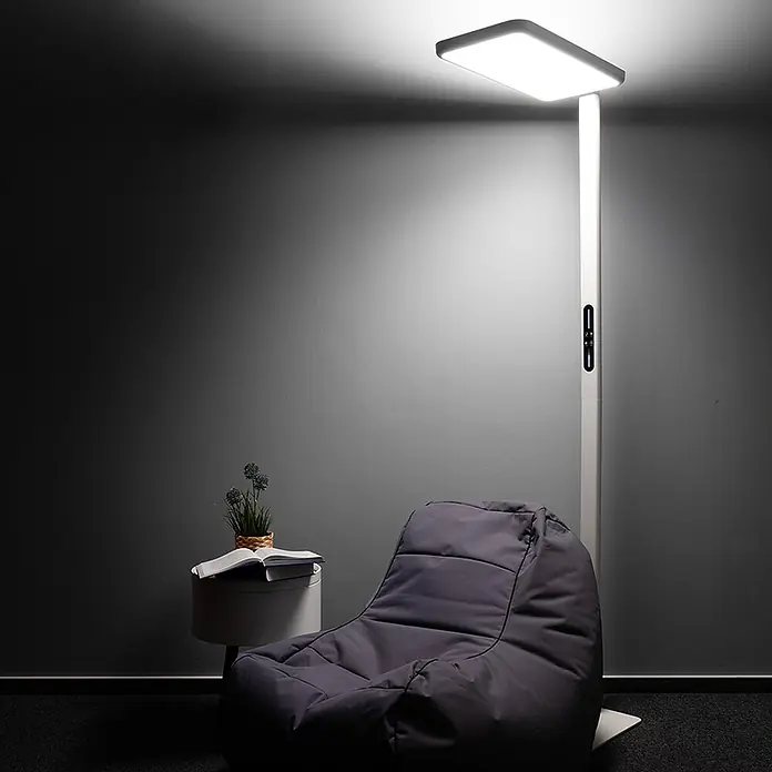 Luxula LED-Stehleuchte Stehlampe Up/Down Bürolampe Weiß 100W 7000LM 4000K -  - Weiße LED-Stehleuchte mit rechteckigem Kopf erhellt einen Bereich neben einem dunklen Sitzsack.