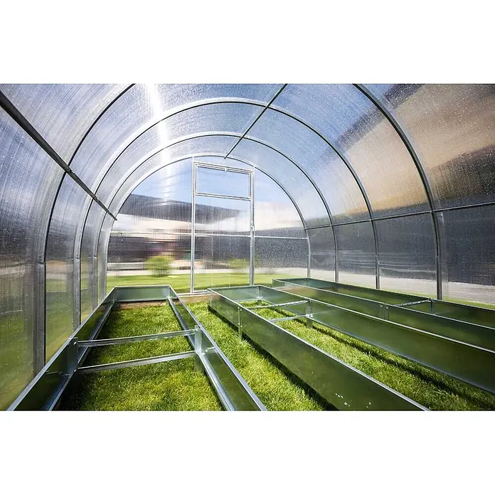 Garten Dream Gewächshaus Optima, 4mm Polycarbonat - 250 x 400 cm, Material Seitenwand: Kunststoff, 4 mm, Silber - Innenansicht eines bogenförmigen Gewächshauses mit lichtdurchlässigen Platten und verzinkten Hochbeeten auf Gras, bereit zur Bepflanzung.