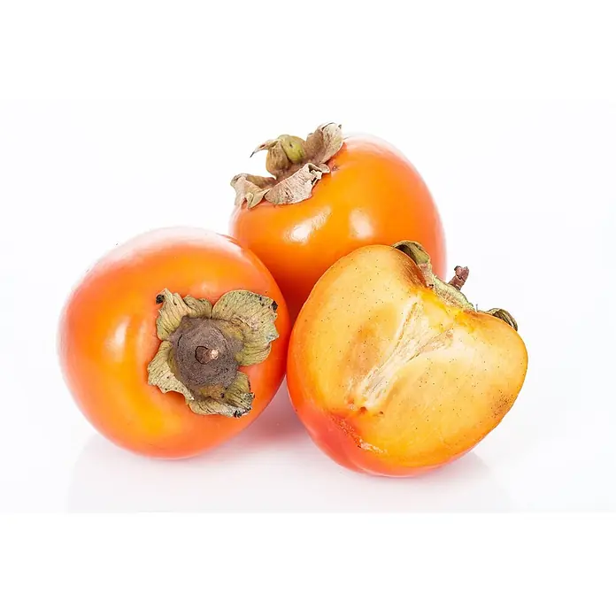 Pflanzen für dich Obstbaum Kaki 'Ernesto' 125-150 cm - Diospyros kaki 'Ernesto' - Kaki - Drei orangefarbene Kakis, zwei ganz und eine halbiert, die ihr Fruchtfleisch zeigt.