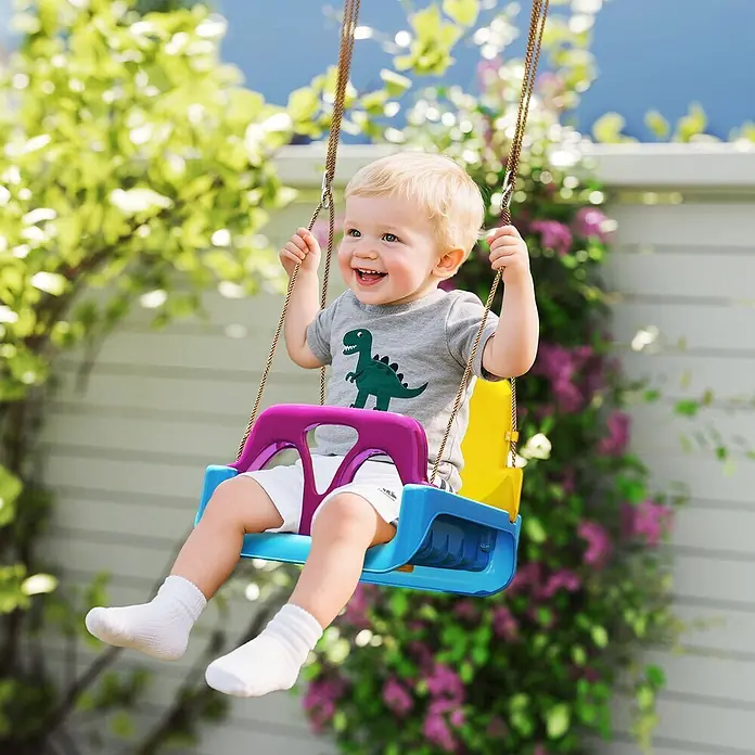 Outsunny Babyschaukel - Kunststoff - Glückliches Baby in einer bunten Kunststoffschaukel mit braunen Seilen, im Freien.