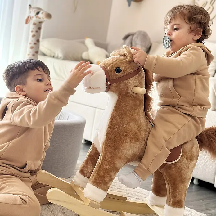 Kinder Schaukelpferd Baby Schaukeltier Pferd Spielzeug Braun -  - Zwei Kinder spielen mit einem braunen Plüsch-Schaukelpferd mit Holzwippen in einem hellen Zimmer.