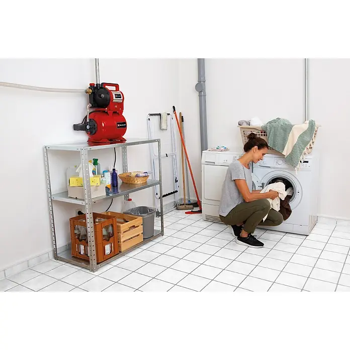 Einhell Hauswasserwerk GC-WW 1045 N - 1.050 W, 20 l, Max. Fördermenge: 4.500 l/h, Max. Druck: 3 bar - Rote Wasserpumpe auf Metallregal in Waschküche, an Schlauch angeschlossen.