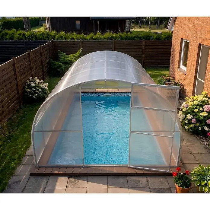Garten Dream Poolüberdachung Marina, 4mm Polycarbonate - L x B x H: 400 x 300 x 210 cm - Eine gewölbte, lichtdurchlässige Schwimmbadüberdachung mit silbernem Rahmen, die einen Außenpool im Garten abdeckt.