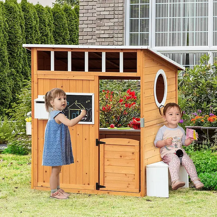 Outsunny Spielhaus - Holz, Naturholz - Hölzernes Spielhaus für draußen mit Tafel, Fenster und kleiner Tür, von zwei Kindern im Garten benutzt.