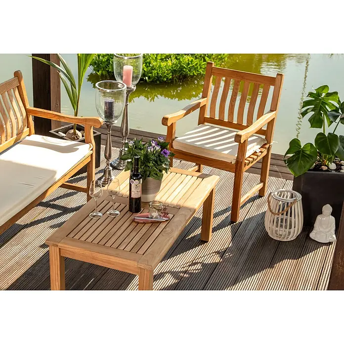 Kai Wiechmann Sitzauflage - Sessel, Polyacryl, Naturweiß - Outdoor-Sitzgruppe aus Teakholz mit zwei Stühlen, cremefarbenen Kissen und einem Couchtisch auf einer Terrasse am Teich.