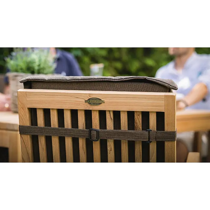 Kai Wiechmann Sitzauflage - Polyacryl, Marineblau - Rückenlehne eines Outdoor-Holzstuhls mit braunem Kissen und Befestigungsgurt, mit Kai Wiechmann Seaside Markenplatte.