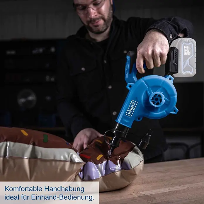 Scheppach IXES 20V Akku-Gebläse C-WBL180-X - 20 V, Ohne Akku - Blaues Scheppach Akku-Gebläse/Pumpe, von einem Mann zum Aufblasen eines braunen Objekts benutzt, ideal für Einhand-Bedienung.