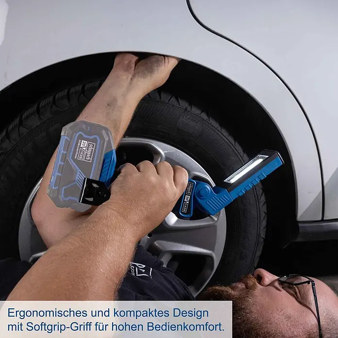 Scheppach IXES 20V LED-Arbeitsleuchte C-WL20-X - 20 V, Ohne Akku, 300 lm - Ergonomische, blaue scheppach Akku-Arbeitsleuchte mit Softgrip und Batterie unter einem Auto im Einsatz.
