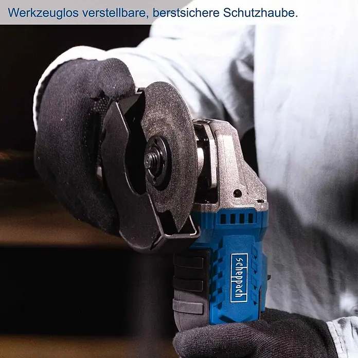 Scheppach IXES 20V Akku-Winkelschleifer C-AG125-X - Ohne Akku, Durchmesser Scheibe: 125 mm - Eine Person mit schwarzen Handschuhen hält einen blauen und grauen Winkelschleifer mit werkzeuglos verstellbarer Schutzhaube.