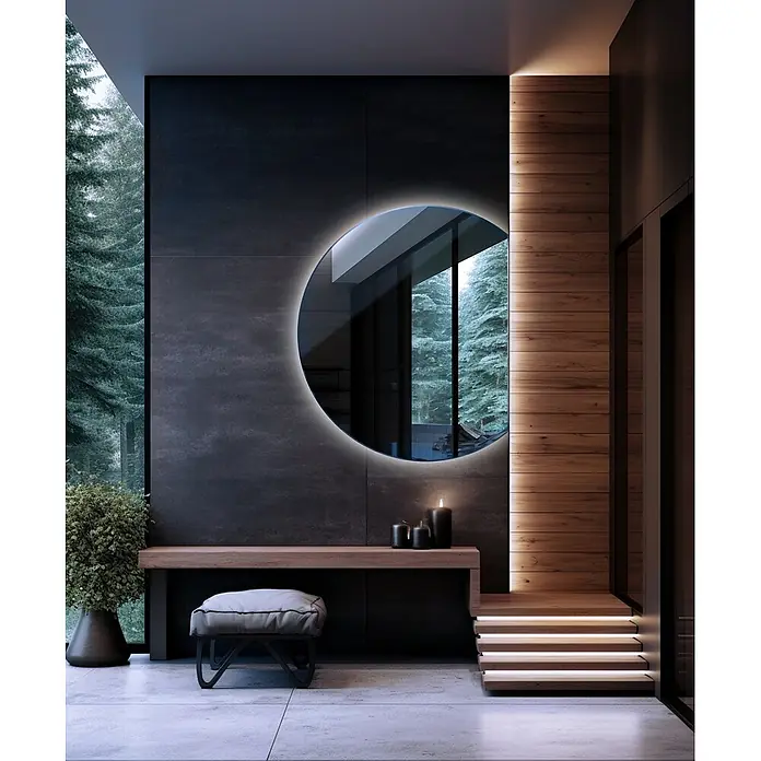 Lustro LED Rita - Zimny - 70x80 cm -  - Ein moderner, runder, hinterleuchteter Spiegel, der einen verschneiten Wald reflektiert, über einem Holzkonsolentisch in einem stilvollen Eingangsbereich.