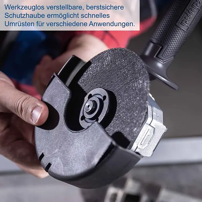Scheppach IXES 20V Akku-Winkelschleifer BC-AG125P-X - 20 V, Ohne Akku, 7.000 U/min - 10.000 U/min - Werkzeuglos verstellbare schwarze Schutzhaube und Schleifscheibe eines Winkelschleifers, von Hand gehalten.