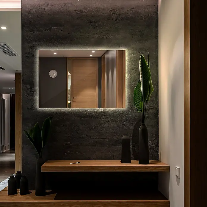 Tulup Wandspiegel -  - Rechteckiger beleuchteter Spiegel an einer dunklen Wand über einer Holzkonsole in einem modernen Flur.