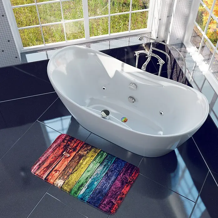 SANILO Badteppich Rainbow 70 x 110 cm - 70 x 110 cm, Polyester, Lila - Eine farbenfrohe, regenbogenfarbene Badematte im Holzplanken-Look, auf dunklen Fliesen im Bad neben einer weißen Badewanne.