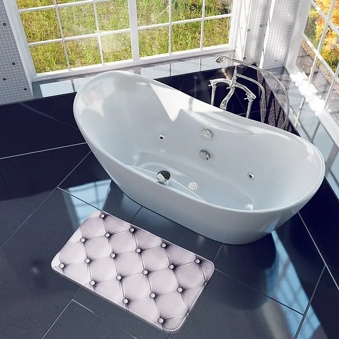 SANILO Badteppich Comfort 70 x 110 cm - 70 x 110 cm, Polyester, Grau - Weiße getuftete Badematte mit Steppmuster, auf dunklen Fliesen neben einer weißen Badewanne.
