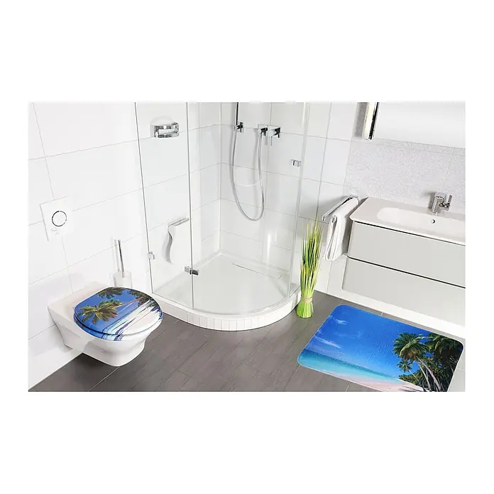 SANILO Badteppich Karibik 50 x 80 cm - 50 x 80 cm, Polyester, Blau - Ein Toilettensitz und eine passende Badematte, beide mit tropischem Strandmotiv, sind in einem modernen Badezimmer ausgestellt.