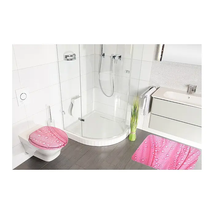SANILO Badteppich Rosa Flower 50 x 80 cm - 50 x 80 cm, Polyester, Rosa - Pinker Toilettensitz und passende Badematte mit Wassertropfen-Design in einem modernen Badezimmer.