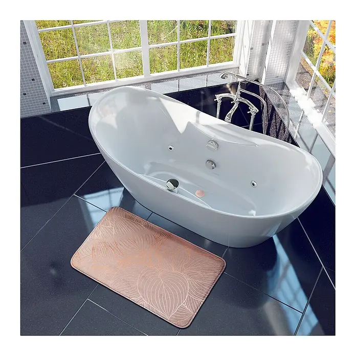 SANILO Badteppich Hosta 50 x 80 cm - 50 x 80 cm, Polyester, Beige - Eine rechteckige roségoldene Badematte mit Blattmuster liegt auf dunklen Fliesen neben einer weißen Badewanne.