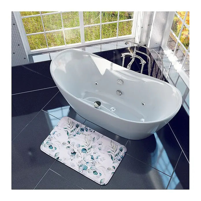 SANILO Badteppich Eukalyptus 50 x 80 cm - 50 x 80 cm, Polyester, Weiß - Helle Badematte mit zartem grün-blauem Blattmuster, auf dunklem Fliesenboden neben einer weißen Badewanne.