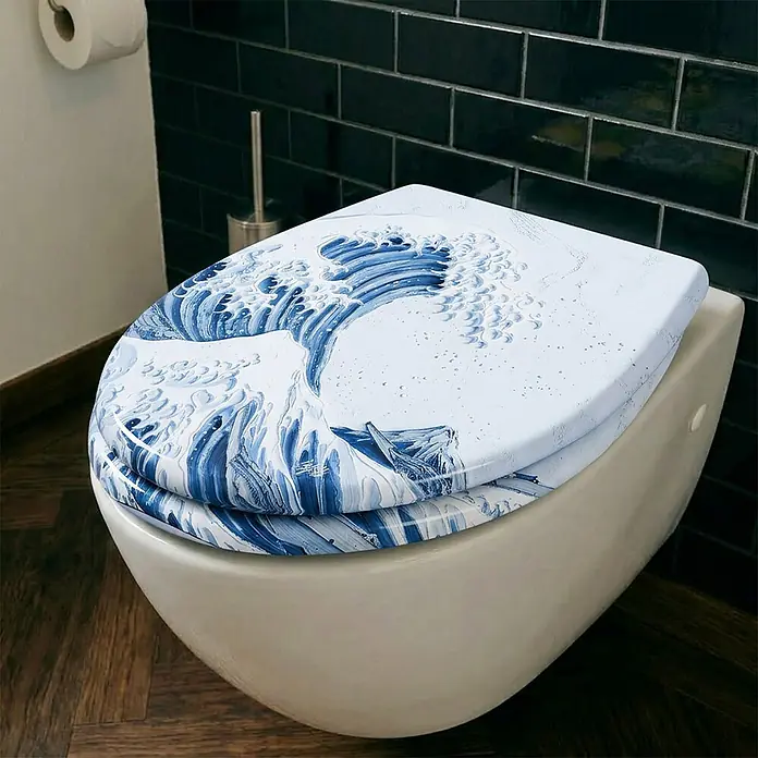 Wodea WC-Sitz   -  Wave -  - Weißer Toilettensitz mit blauem 'Große Welle' Design, auf einer Toilette installiert.