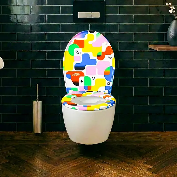 Wodea WC-Sitz   -  Colors -  - Weißes WC mit bunt gemustertem, abstraktem Toilettensitz und Deckel in einem modernen Bad.