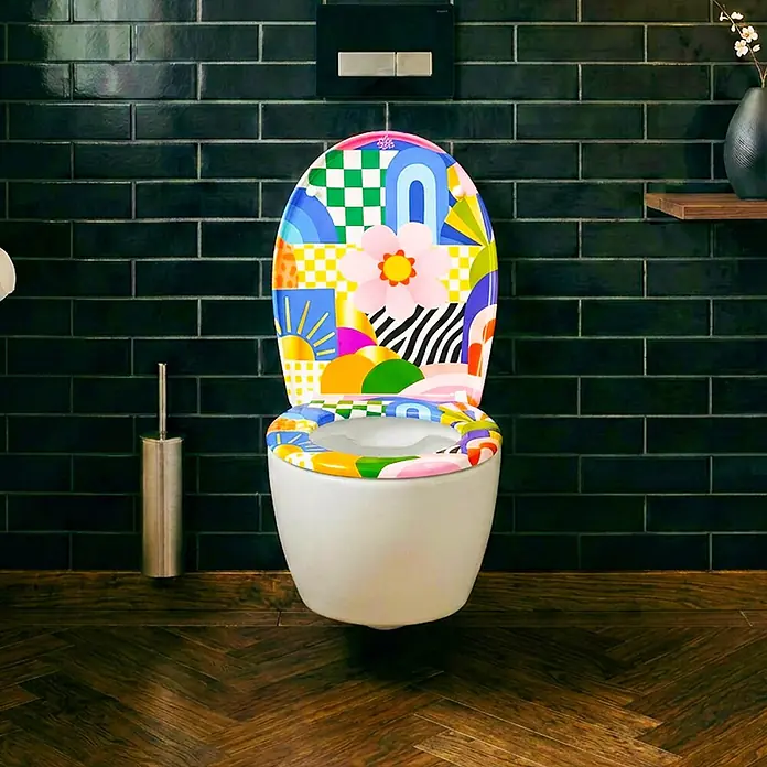 Wodea WC-Sitz   -  FlowerPower -  - Eine moderne weiße Toilette mit bunt gemustertem Deckel und Sitz in einem stilvollen Badezimmer.