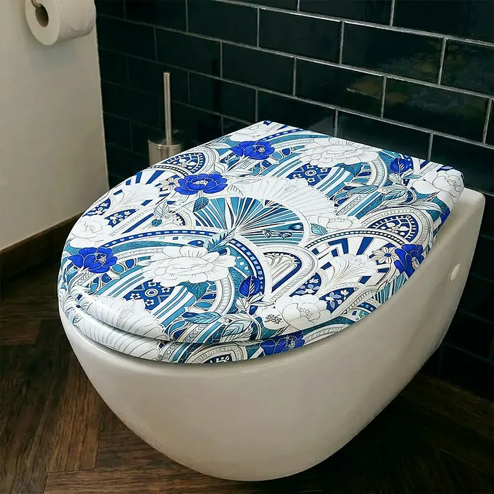 Wodea WC-Sitz   -  Wallpaper -  - Toilettensitz mit blau-weißem Blumen- und Geometriemuster, auf einer weißen Toilette installiert.