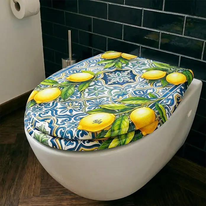 Wodea WC-Sitz   -  Citrons -  - Toilettensitz mit leuchtendem Zitronen- und blauem Fliesenmuster, auf einer weißen Toilette im Bad montiert.