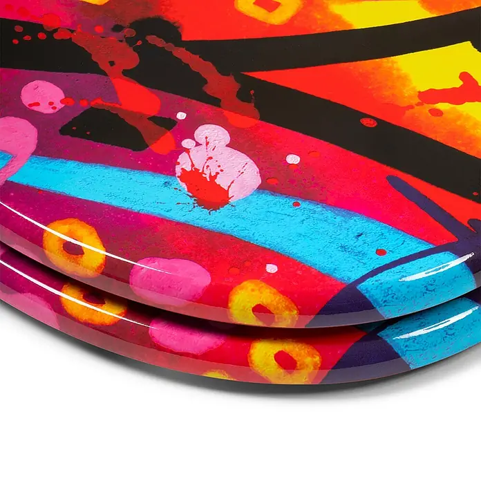 Tohaa Design WC-Sitz StreetSun - Blazer -  - Zwei gestapelte Teller mit einem leuchtenden, glänzenden, abstrakten Graffiti-Design in Rot, Gelb, Pink, Blau und Schwarz.