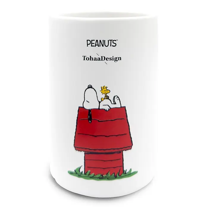 Tohaa Design Zahnputzbecher Peanuts Snoopy - Peanuts -  - Weißer Keramikbecher mit Peanuts-Logo, TohaaDesign-Schriftzug und Snoopy mit Woodstock auf einer roten Hundehütte.